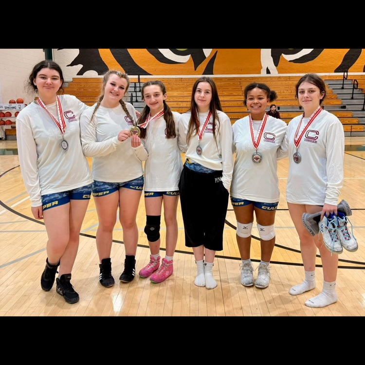 Girls wrestlers posing with their medals.