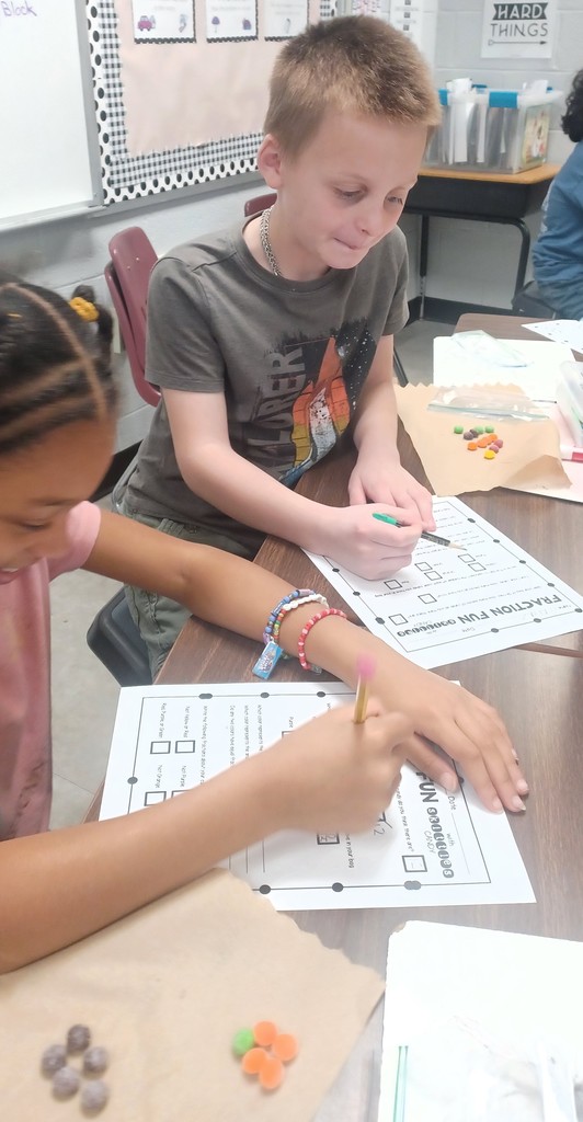 Pictured here are Ms. Ciccarone's 3rd graders practicing fractions of a group with Skittles fractions - this makes math even sweeter!