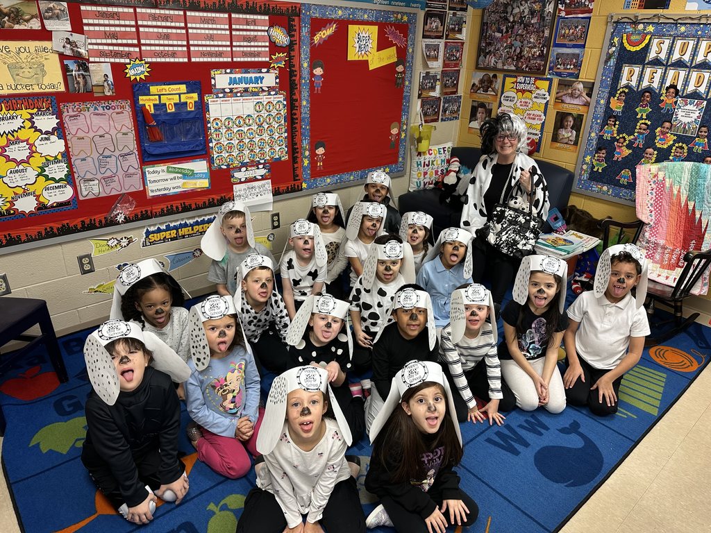 A large group of students and their teacher pose together wearing Dalmatian-themed hats and face paint to celebrate the 101st Day of School.