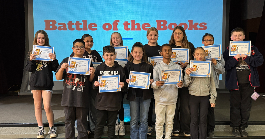 Fifth grade students pose on stage with certificates after participating in the school’s Battle of the Books competition.