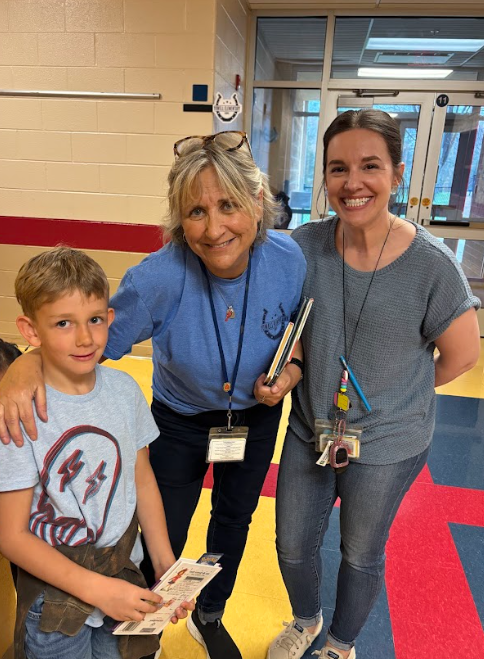 “Two school staff members and a student stand together in a hallway, smiling and wearing blue in support of Autism Awareness Day.”