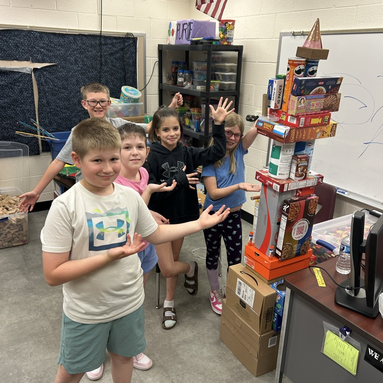 students standing by a tower of 3d shapes 