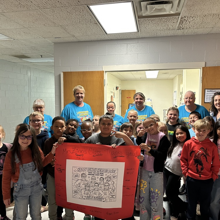 staff posing with a class and a sign 