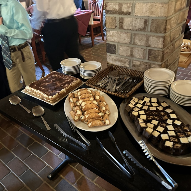 students are pictured here, making their plates and enjoying food at Luigi’s restaurant