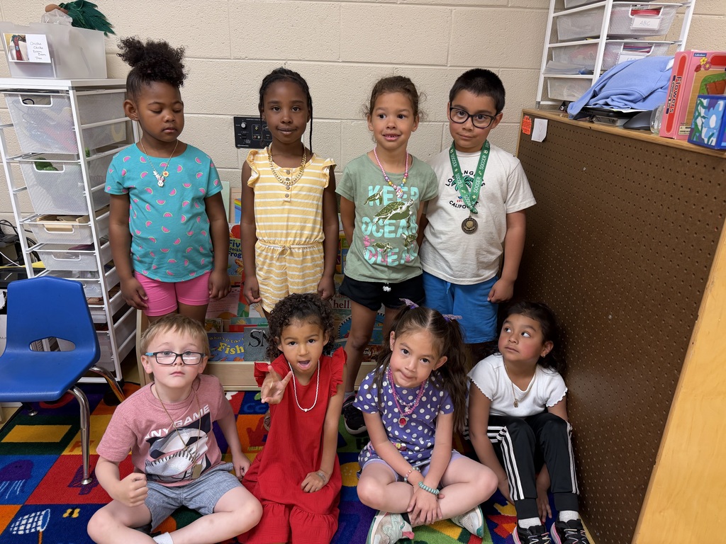 eight preschool students pose for a picture showing off their necklaces for the letter N day