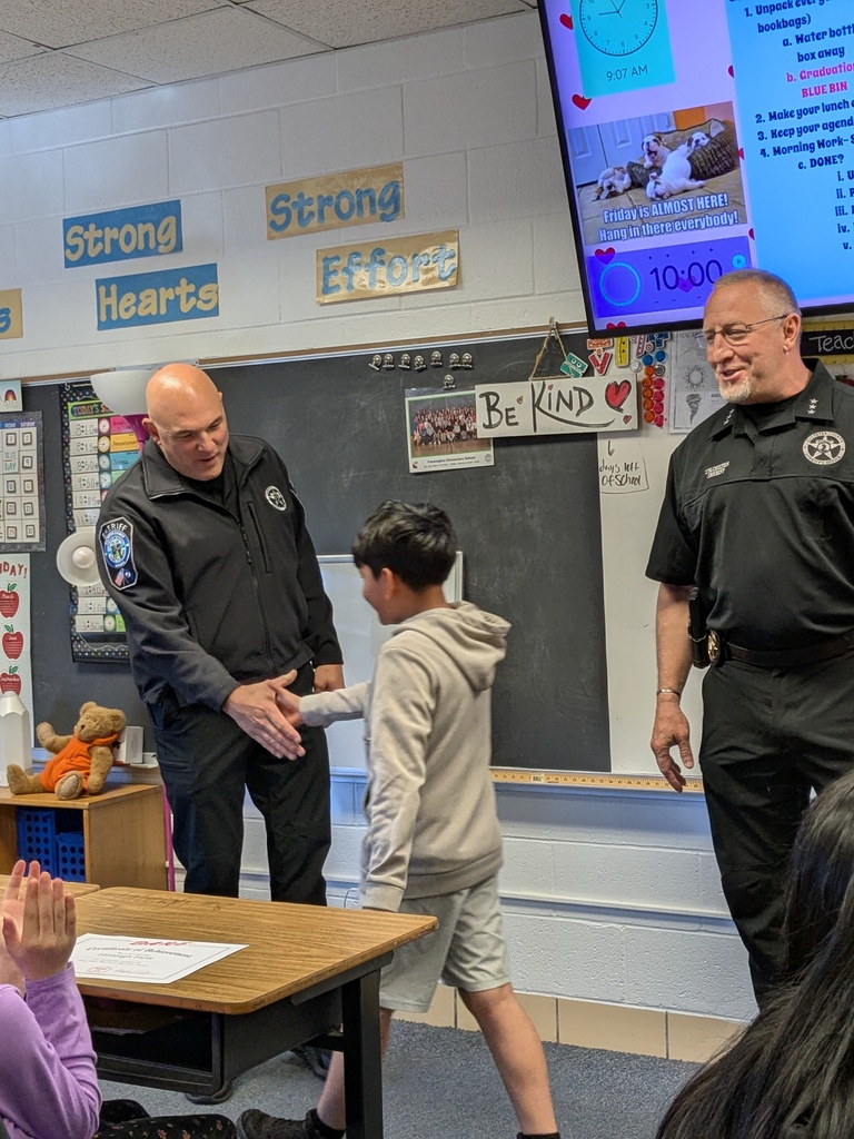 A fifth grade student shakes hands with a Culpeper County Sheriff’s Office deputy while receiving a D.A.R.E. graduation certificate in a classroom ceremony.