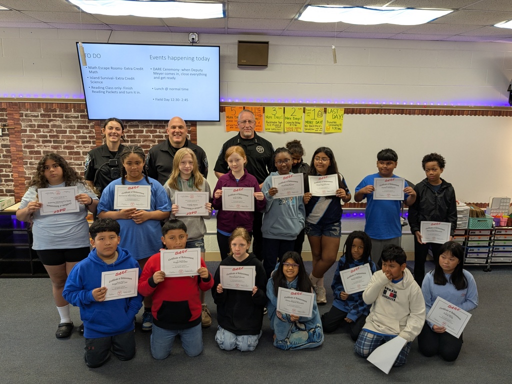 Fifth grade students pose with D.A.R.E. graduation certificates and CCSO deputies during a classroom celebration at Farmington Elementary Scho