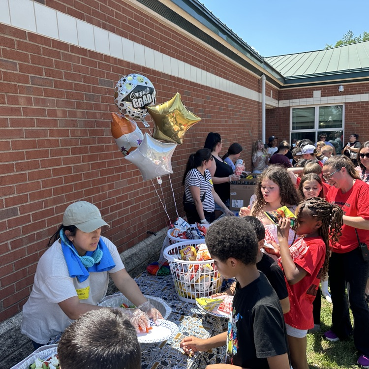 outside fifth grade party showing students enjoying fun and games and food