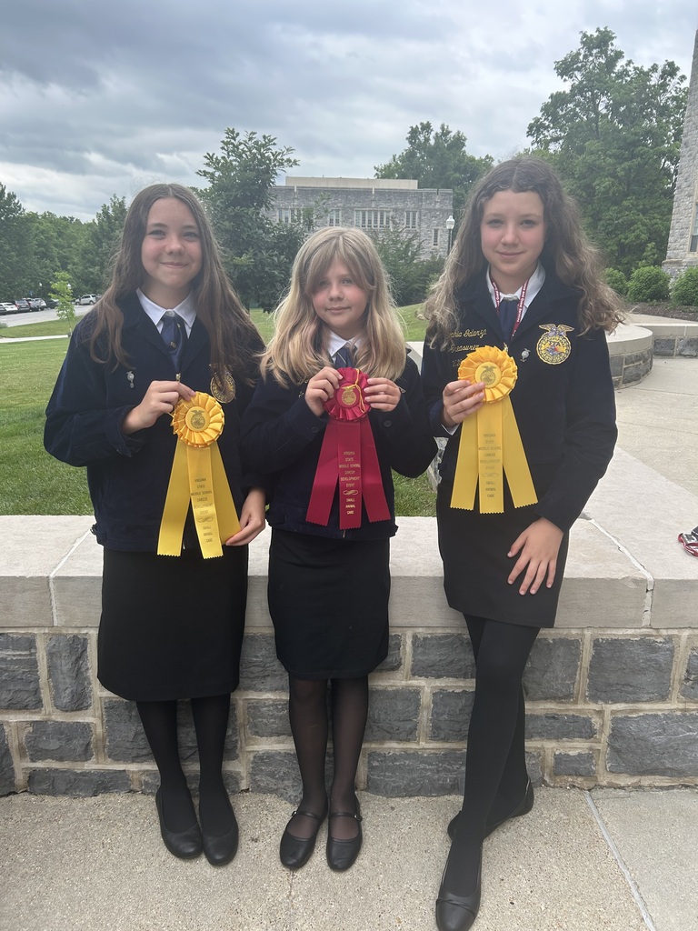 Three Culpeper Middle School FFA students from the Small Animal Care team pose with their competition awards at Virginia Tech. Two students hold large yellow ribbons, while the student in the center displays a red ribbon earned during the Virginia FFA Career Development Event competition.