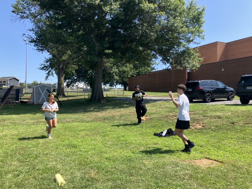 Students playing in a grassy field.