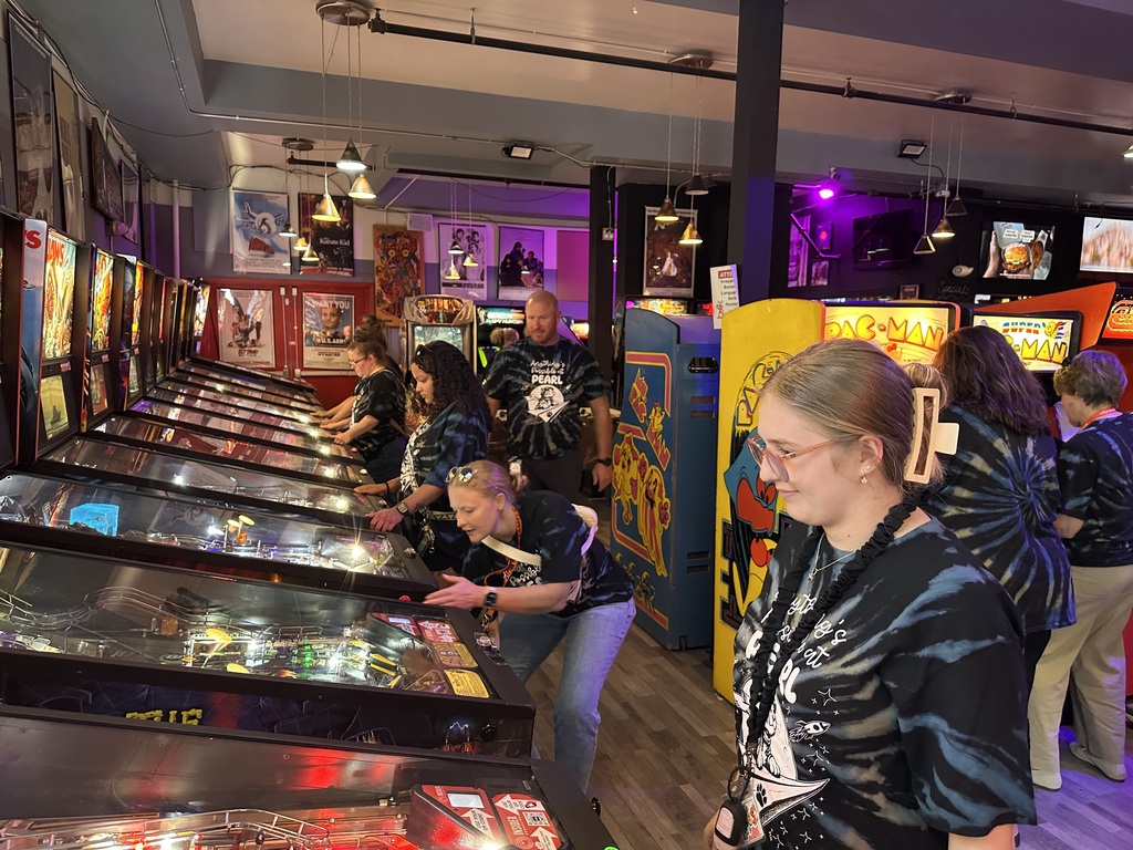 Pearl Sample staff members play pinball and other classic games together during their back-to-school outing at Throwbacks Arcade.