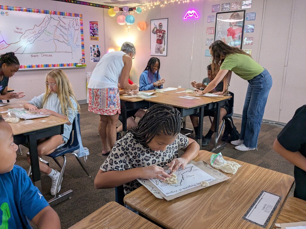 Students use dough to create maps of Virginia’s geographic regions during a hands-on classroom activity while teachers assist.