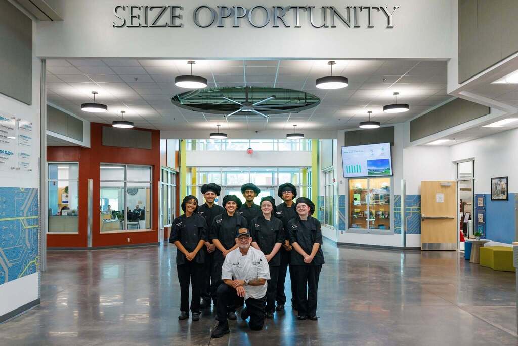 Culinary Arts students and their instructor gather beneath CTEC’s “Seize Opportunity” message, showcasing the teamwork, professionalism, and career-ready skills at the heart of the program.
