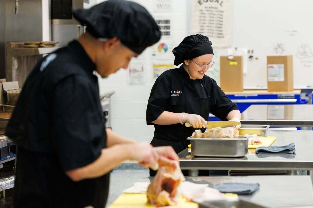 Culinary Arts students build real-world kitchen skills through hands-on food preparation, practicing safe knife techniques, teamwork, and professional kitchen procedures.