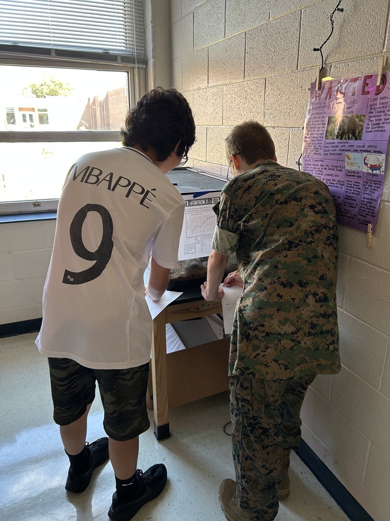 Two individuals, one in a military uniform and another in a white jersey with number 9, are standing.