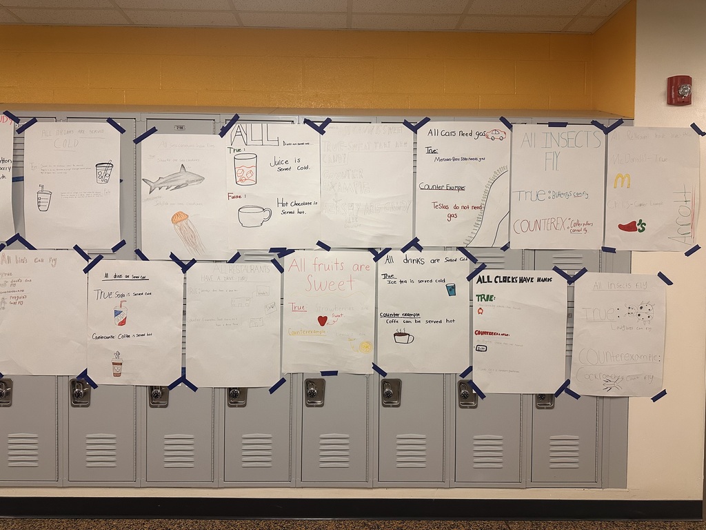 A row of lockers with several sheets of paper pinned to them. Each paper has drawings and text.