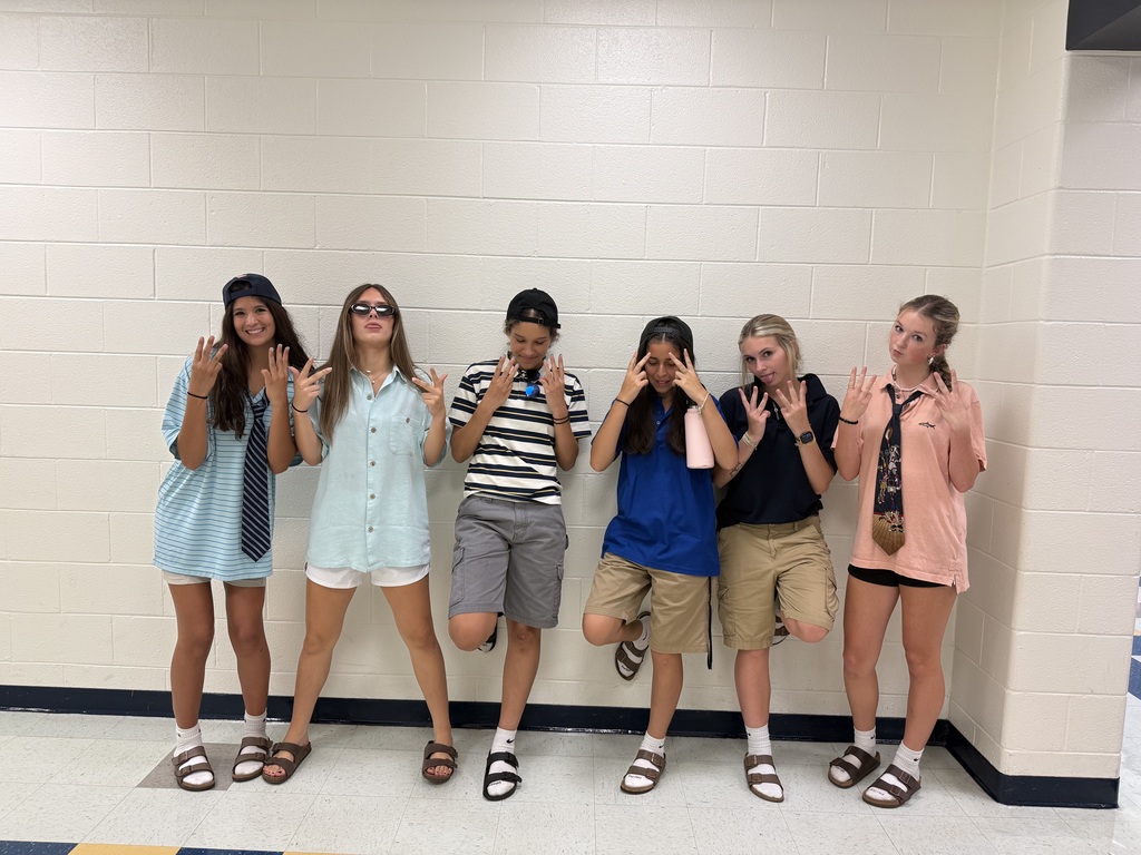 High schoolers in front of a block wall
