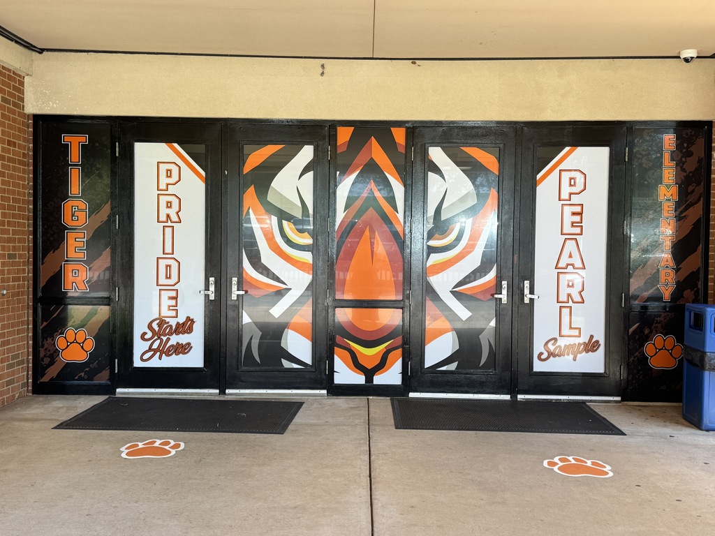 Entrance to a building with large glass doors. Each door has an orange tiger face. Words "TIGER PRIDE" and "PEARL" are on the doors.