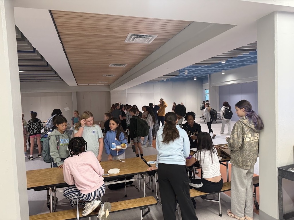 Students gather around cafeteria tables at Culpeper Middle School during International Dot Day, participating in activities and spending time together.
