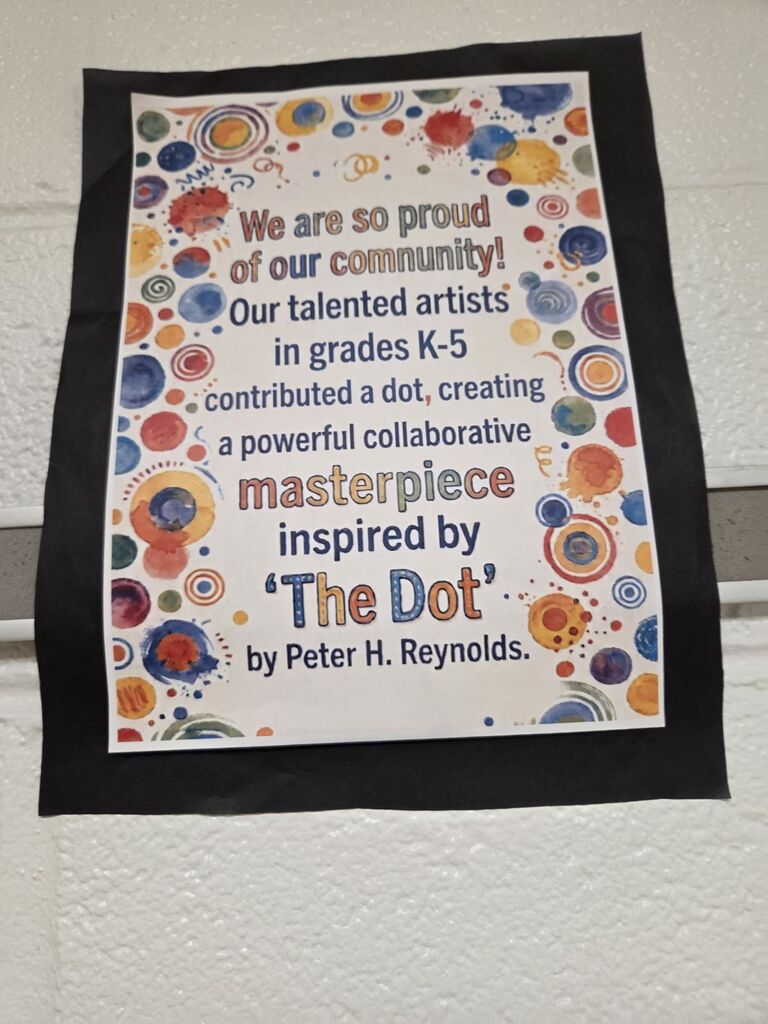 A colorful bulletin board displays a message about a collaborative artwork made by students in grades K-5. The design features dots in multiple colors.