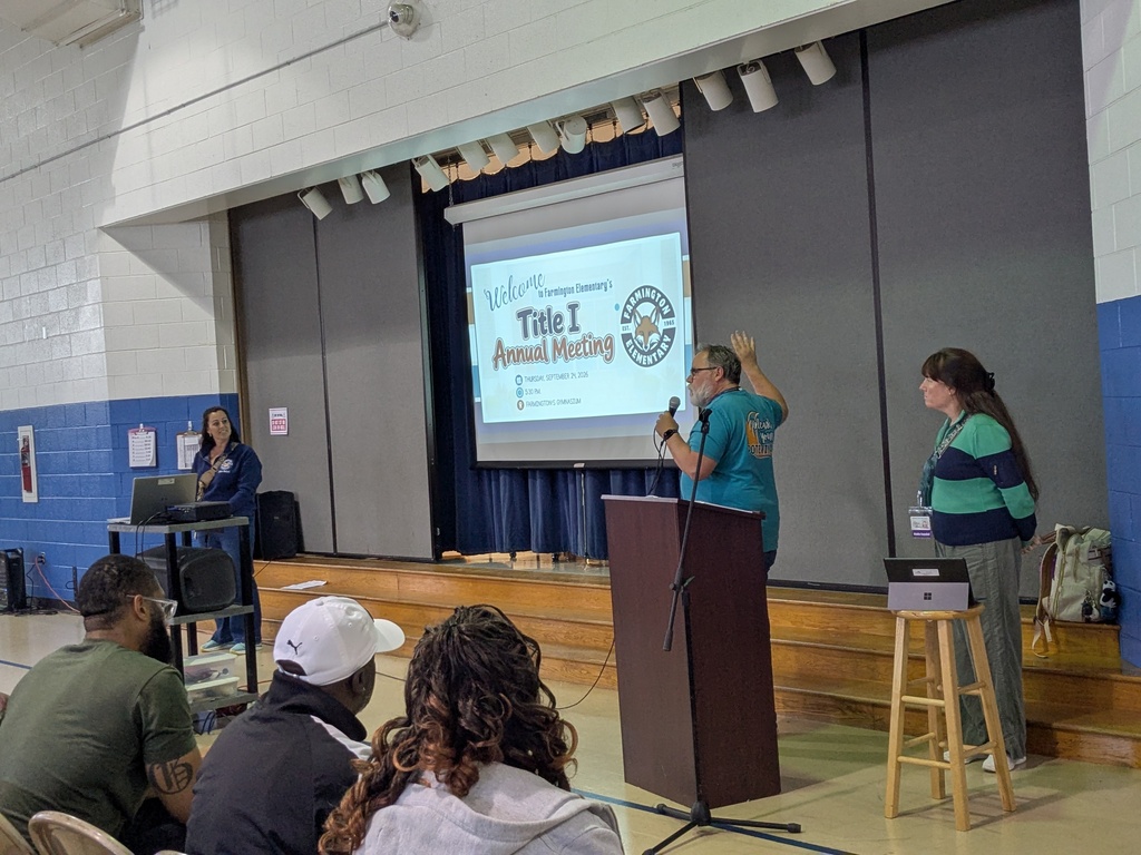 Staff present for the Title 1 Annual Meeting in front of a crowd. 