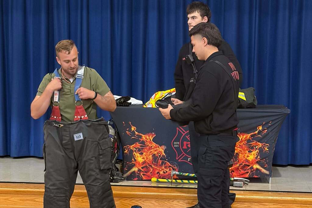 CTEC Firefighting students demonstrate firefighting gear while teaching first graders about fire safety during the Day of Career Exploration.