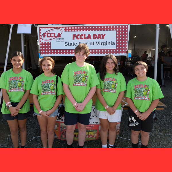 1. Five Culpeper Middle School FCCLA students wearing matching bright green “FCCLA is a Big Dill” shirts smile for a group photo in front of the FCCLA Day at the State Fair of Virginia display.