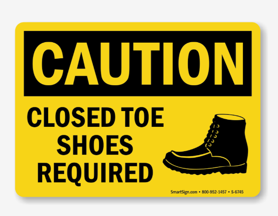 Yellow sign with black borders reading "Caution Closed Toe Shoes Required" and a black boot icon.