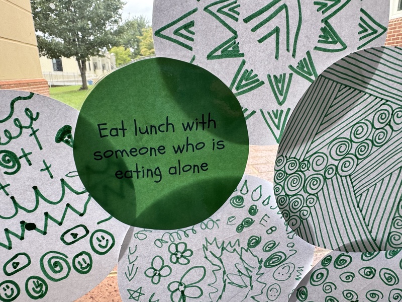 green circle that says eat lunch with someone who is eating alone with other decorated circle around it
