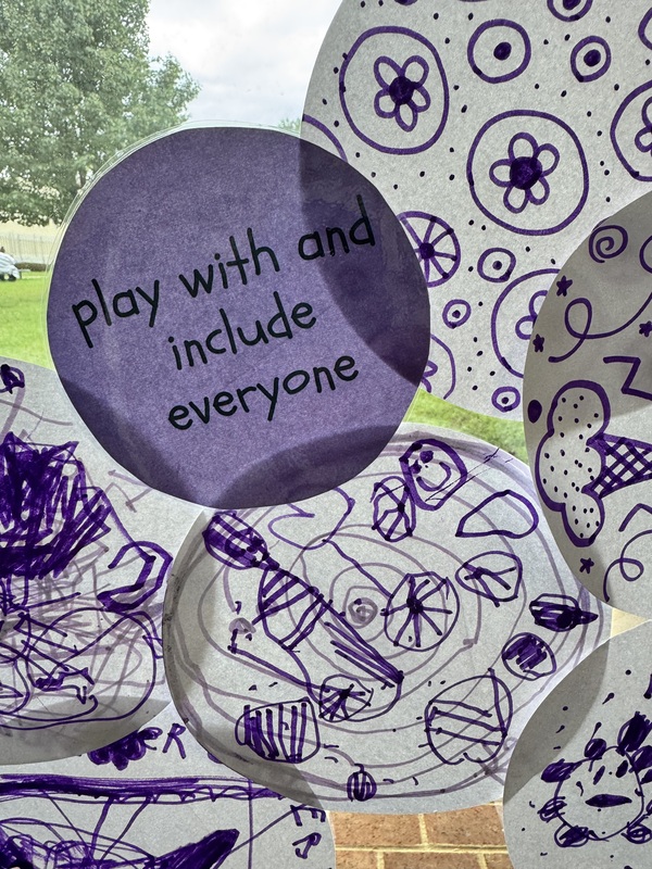 a purple circle that says play with and include everyone