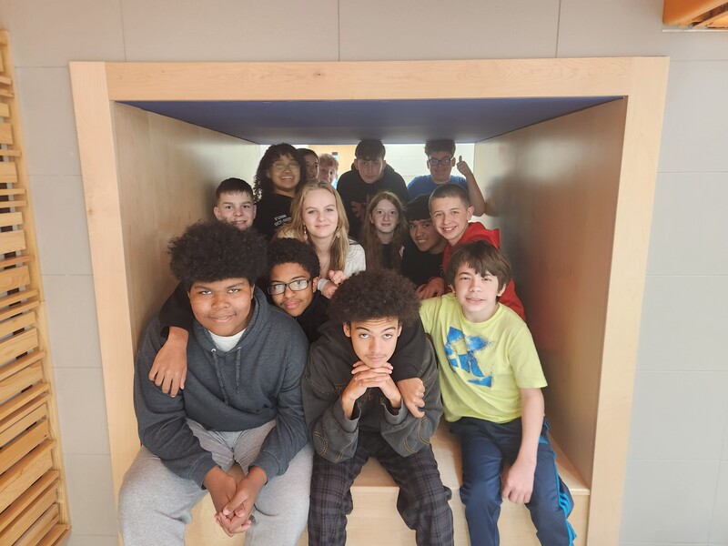 students sitting in a cubby space under stairwell