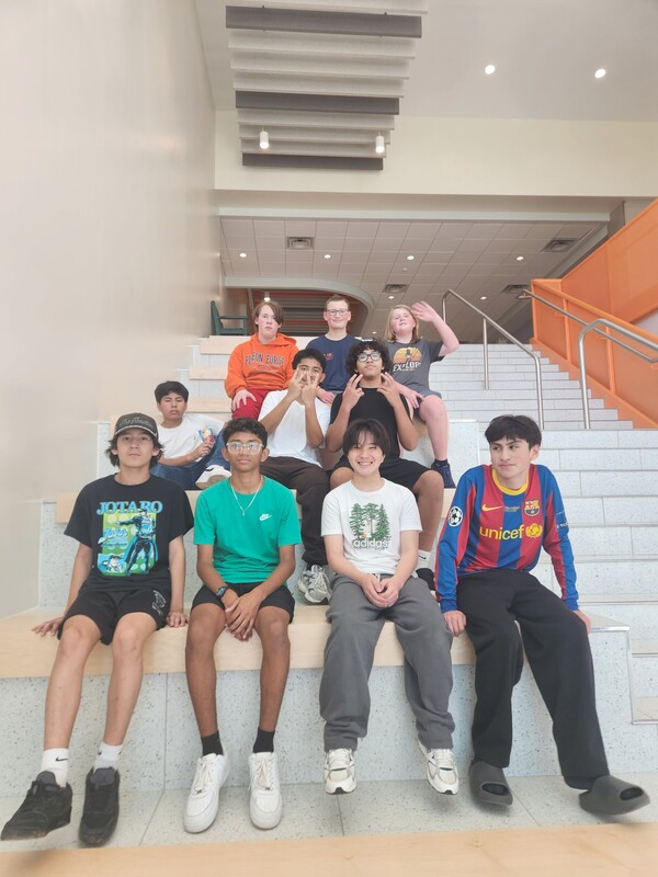 students sitting on monumental staircase of new CMS building