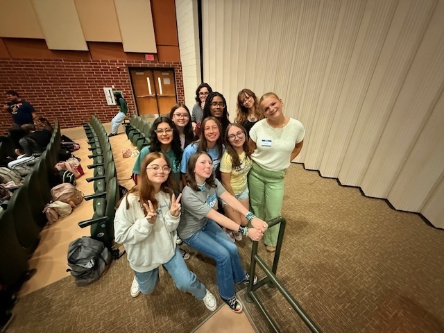 group of high school students smiling in school auditorium