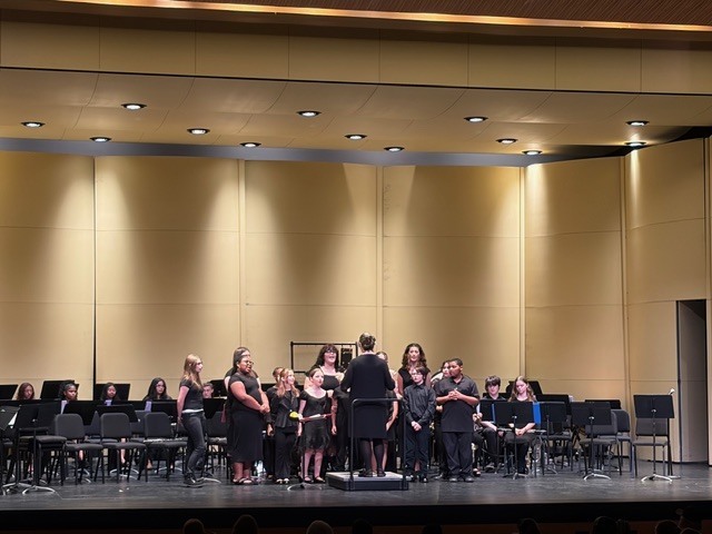 Chorus students perform on stage.