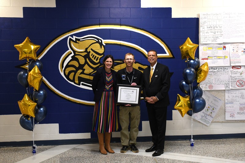 State Superintendent of Education, Jenna Conway, (left) and Secretary of Education, Dr. Jeffrey Smith (right) present Lewis Longenecker (center) with a certificate for being named the Gilder Lehrman History Teacher of the Year. 