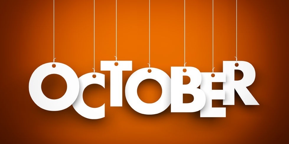 October in white letters hanging from string on an orange background