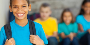 Image of smiling student with out of focus students in the background