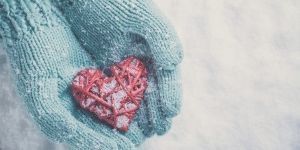 winter gloves holding yarn heart