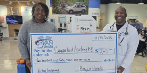 woman and man holding oversized donation check