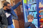 student selecting book out of book vending machine