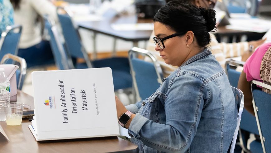 Parent with binder at meeting