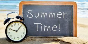 Image of chalkboard with words Summer Time and clock on sandy beach