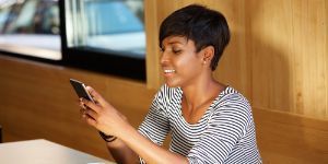 Image of woman sitting at table with cell phone