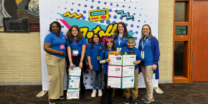 members of the news broadcast team in front of NCTIES backdrop