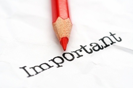 red colored pencil and a paper with the work important on it