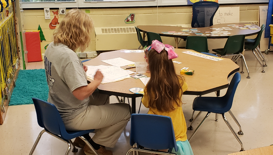 Teacher and student at desk