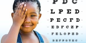 image of child covering one eye and a vision screening chart