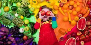 Image of girl surrounded by fruits and vegetables