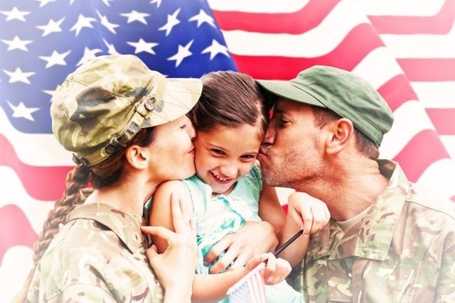 image of two military parents kissing their child