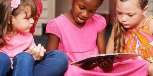 image of three girls reading a book